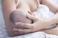 Mother holds her baby head while he is breastfed