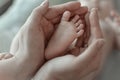 mother holds her baby's tiny foot in her hands