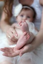 Mother holds in her palms the feet of the feet of her newborn daughter Royalty Free Stock Photo