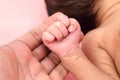 Mother holds newborn babys hand