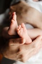 A mother holds the small legs of her newborn baby in her hands. Royalty Free Stock Photo