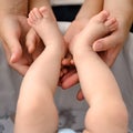 A mother holds the small legs of her newborn baby in her hands. Royalty Free Stock Photo