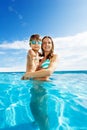 Mother holds son with goggles and smiles in pool Royalty Free Stock Photo