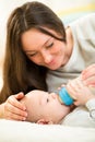 Mother at home feeding baby boy with a milk bottle Royalty Free Stock Photo