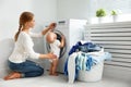 Mother housewife with baby engaged in laundry fold clothes into Royalty Free Stock Photo