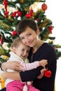 Mother hugging daughter under Christmas tree Royalty Free Stock Photo