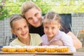 Mother hugging her daughters cook delicious cupcakes Royalty Free Stock Photo