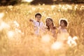 Mother hugging her son and daughter in a wheat field