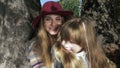 Mother hugging her sweet daughter in a sunny autumnal park, outdoors.