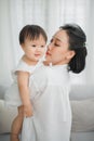 Mother hugging and kissing her little girl in living room, Kid at home Royalty Free Stock Photo