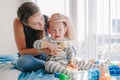 Mother hugging pacifying sad upset crying toddler boy. Family young mom and crying baby sitting on a bed at home. Bonding Royalty Free Stock Photo