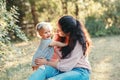 Mother hugging pacifying sad upset stressed crying toddler girl. Family young mom and crying baby in park outdoor. Bonding Royalty Free Stock Photo