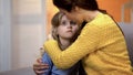 Mother hugging sad little adorable girl home after work, family love and care Royalty Free Stock Photo