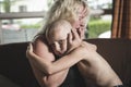 Mother hugs crying living room son