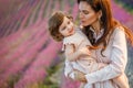 Mother hugs daughter at sunset in the lavender field.