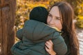 Mother hugs her little asian son outdoors. Happy child walking in autumn park. Toddler baby boy wears trendy jacket and Royalty Free Stock Photo