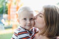 Mother hugs and kissing her baby boy on the park. Motherhood - young mother hugging her happy baby on the park. Woman Royalty Free Stock Photo