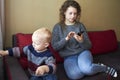 Mother is indifferent to her little son, mom looks at the smartphone, the child needs attention