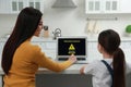 Mother installing parental control in kitchen, back view. Child safety