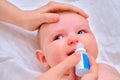 Mother instills nasal drops in Infant baby, face close-up Royalty Free Stock Photo