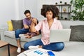 Mother of interracial family working using computer laptop at home pointing down looking sad and upset, indicating direction with Royalty Free Stock Photo