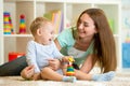 Mother and kid boy play together indoor at home