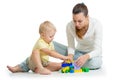 Mother and kid build out of colorful plastic blocks. Family and childhood concept