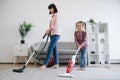 Mother and kid cleaning home with electrical appliances