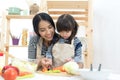 Mother and kid girl cooking and cutting vegetables Royalty Free Stock Photo