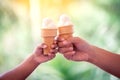 Mother and kid hands holding melting ice cream waffle cone Royalty Free Stock Photo