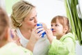 Mother and kid with neti pot for nasal irrigation