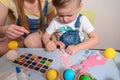 Mother with kid paint eggs