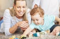 Mother, kid and play learning block toys on floor for educational bonding time together in family home. Young, caring Royalty Free Stock Photo