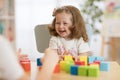 Mother and kid daughter playing colorful block toys at home