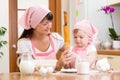 Mother and kid preparing cookies together at kitchen