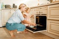 Mother and kid remove from the oven baking sheet