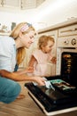 Mother and kid remove from the oven baking sheet