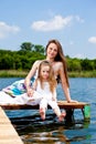 Mother and kid sit on bridge Royalty Free Stock Photo