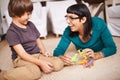 Mother, kid and toy with dinosaur, floor and play for joy or fun at family home or house. Woman, child and bedroom with