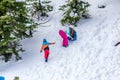 Mother and Kids Enjoy Riding on Ice Slide on a Snowy Day.Children and Parents have Fun on a Snowy Hill. Outdoor Winter Activities Royalty Free Stock Photo