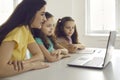 Mother and kids looking computer laptop screen sitting at home desk side view Royalty Free Stock Photo
