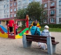 Mother and kids playing on the playground in the yard