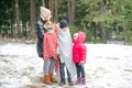 Mother and kids with spaniel laugh and have fun in winter forest. Woman warm up under blankets little son and puppy. Royalty Free Stock Photo