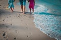 Mother with kids walk on beach leaving footprints in sand Royalty Free Stock Photo