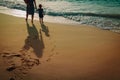 Mother and kids walking on beach leaving footprint in sand Royalty Free Stock Photo