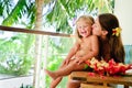 Mother kiss her daughter at tropical garden