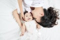 Mother kisses baby lying on the bed closeup Royalty Free Stock Photo