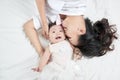 Mother kisses baby lying on the bed closeup Royalty Free Stock Photo