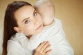 Mother kisses child in cheek, baby rests on mom shoulder Royalty Free Stock Photo