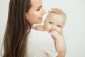 Mother kisses child in cheek, baby rests on mom shoulder Royalty Free Stock Photo